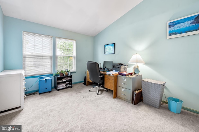 carpeted office with lofted ceiling and baseboards