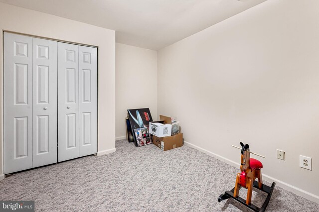 recreation room featuring baseboards and carpet flooring