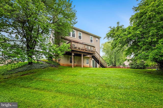 back of house featuring a deck, a yard, and stairway