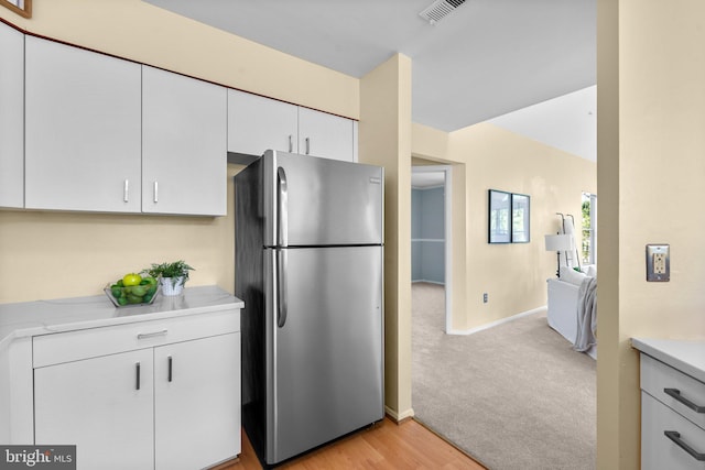 7617 Stony Creek Ln, Ellicott City, MD 21043 - kitchen featuring freestanding refrigerator, light countertops, white cabinetry, baseboards, and light carpet