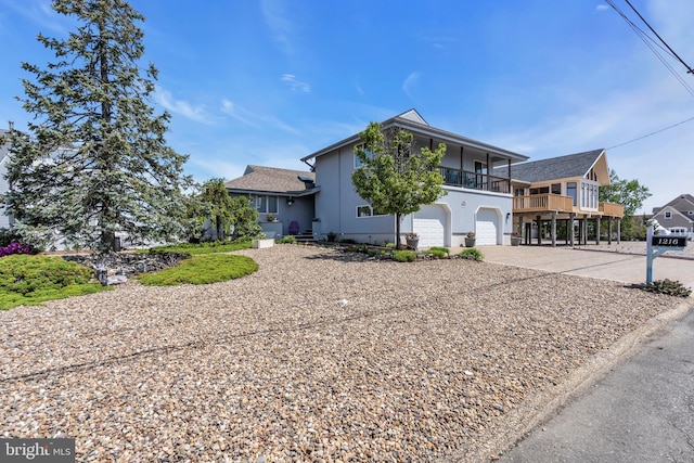 view of front facade with driveway, a garage, a balcony, and stucco siding