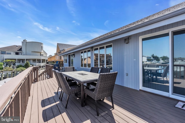 deck featuring outdoor dining area and a residential view
