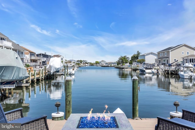 dock area featuring a fire pit, a water view, and a residential view