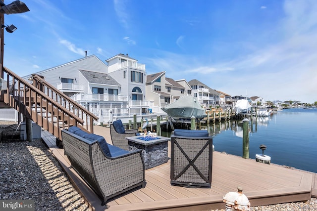 dock area featuring an outdoor fire pit, a water view, stairs, and a residential view