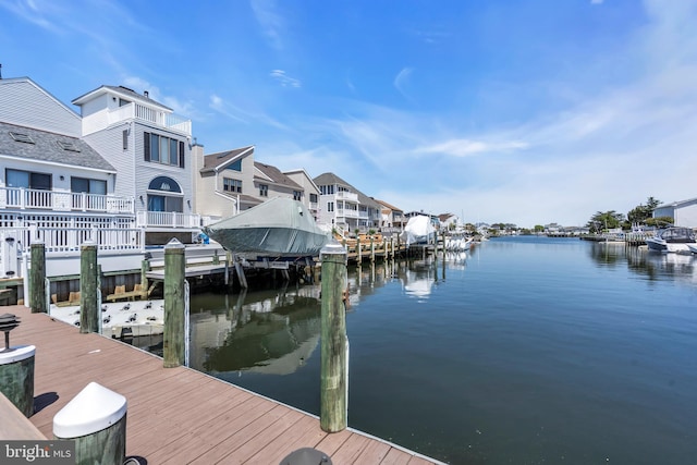 dock with a water view, a residential view, and boat lift