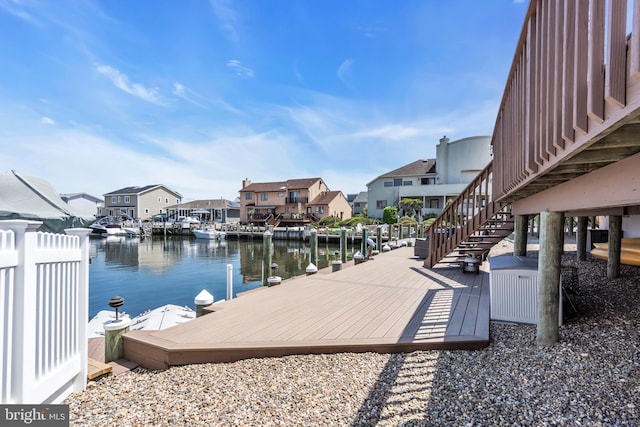 dock area featuring a water view, a residential view, and stairs