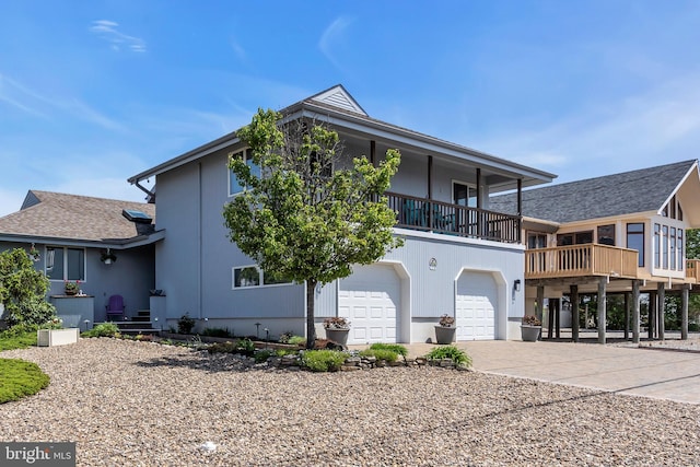 view of front of house featuring a garage, driveway, and a balcony