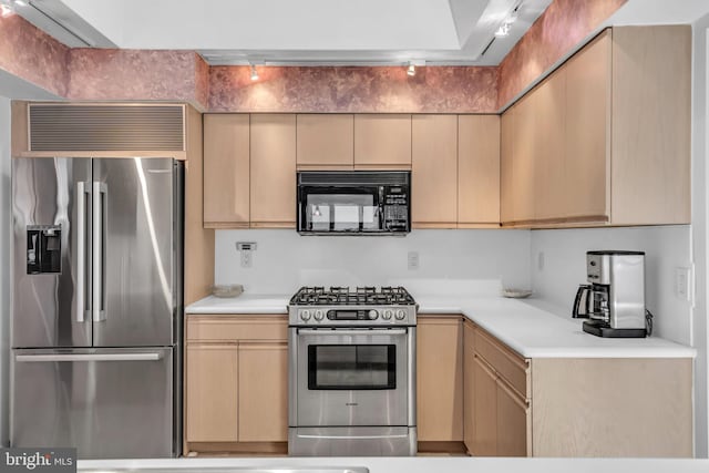 kitchen featuring appliances with stainless steel finishes, light countertops, light brown cabinets, and track lighting