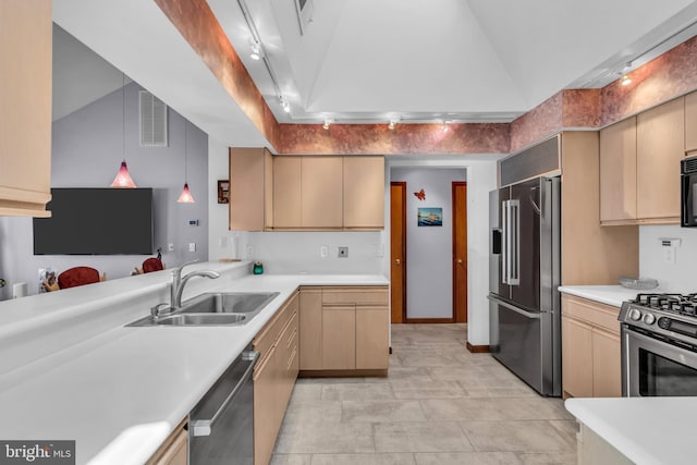 kitchen with appliances with stainless steel finishes, a sink, light countertops, vaulted ceiling, and hanging light fixtures