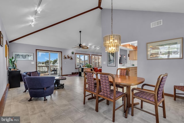dining area with a chandelier, rail lighting, high vaulted ceiling, a ceiling fan, and baseboards