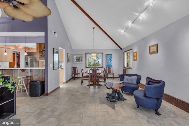 living area featuring a chandelier, baseboards, rail lighting, high vaulted ceiling, and a baseboard heating unit