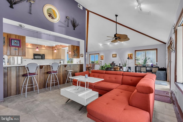 living area with high vaulted ceiling and ceiling fan