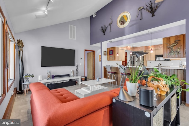 living area with high vaulted ceiling and track lighting