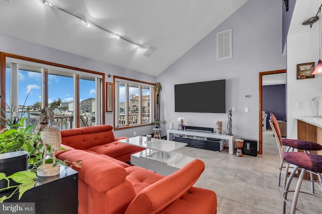 living room with track lighting and high vaulted ceiling