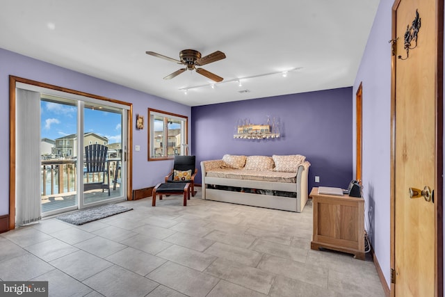 sitting room with ceiling fan and baseboards