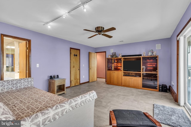 bedroom featuring rail lighting, ceiling fan, and baseboards