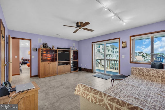 bedroom featuring access to outside, track lighting, a ceiling fan, and baseboards