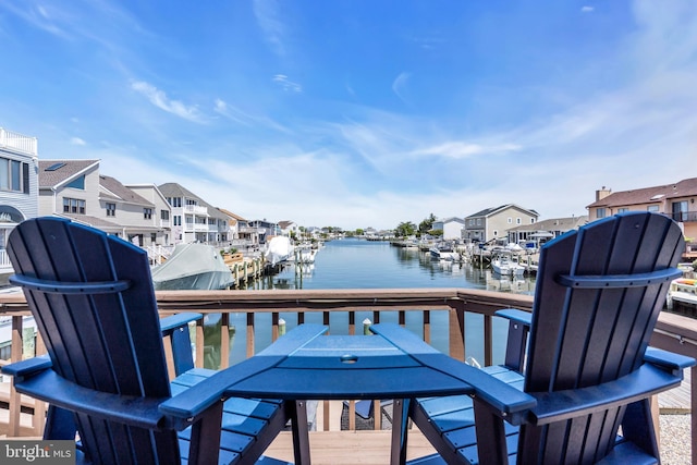 dock area with a water view, outdoor dining area, and a residential view