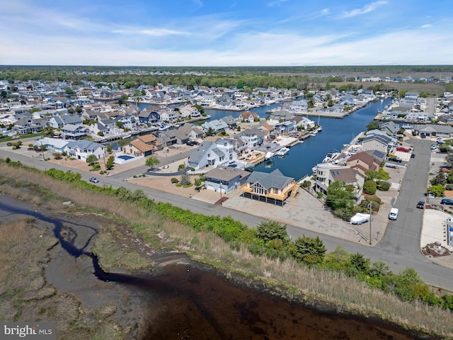 aerial view of property and surrounding area featuring nearby suburban area and a large body of water