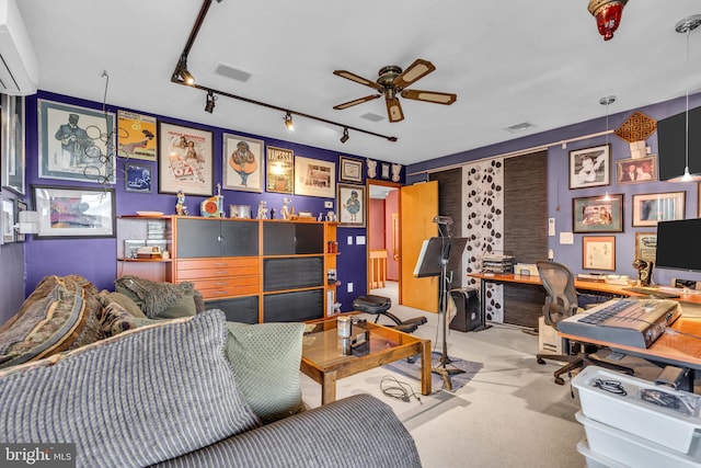 living area with a ceiling fan, a desk, carpet flooring, track lighting, and a wall unit AC