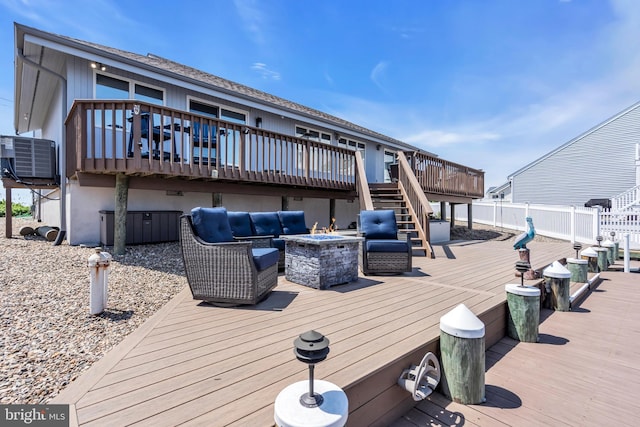 deck with stairs, an outdoor living space with a fire pit, and central air condition unit