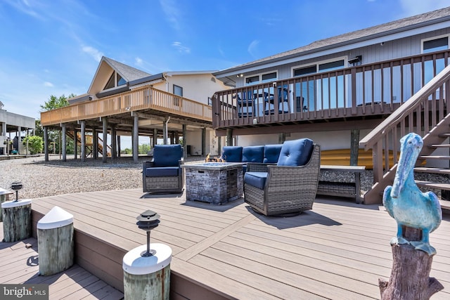 deck featuring stairway and an outdoor living space with a fire pit