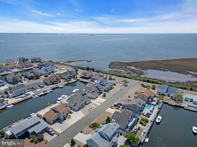 aerial view of property and surrounding area with a nearby body of water and nearby suburban area