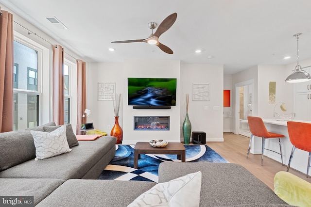 23650 Havelock Walk Ter Unit 303, Ashburn, VA 20148 - living room with light wood-style flooring, recessed lighting, ceiling fan, a glass covered fireplace, and baseboards