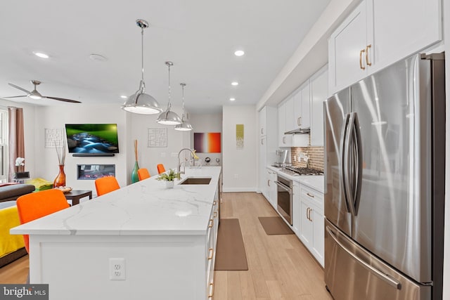 23650 Havelock Walk Ter Unit 303, Ashburn, VA 20148 - kitchen with appliances with stainless steel finishes, a sink, a kitchen island with sink, white cabinetry, and backsplash