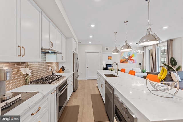 23650 Havelock Walk Ter Unit 303, Ashburn, VA 20148 - kitchen with appliances with stainless steel finishes, a sink, a center island with sink, decorative backsplash, and white cabinets