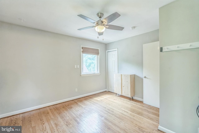 unfurnished bedroom with wood finished floors, baseboards, and a closet