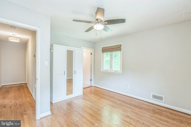 unfurnished bedroom featuring baseboards, light wood-style floors, and ceiling fan