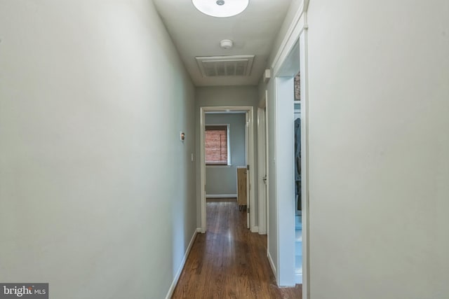 corridor with wood finished floors and baseboards