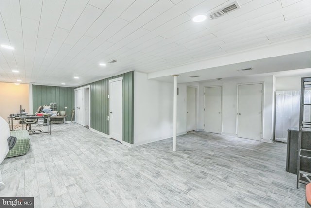 below grade area with light wood-style floors, recessed lighting, and an office area