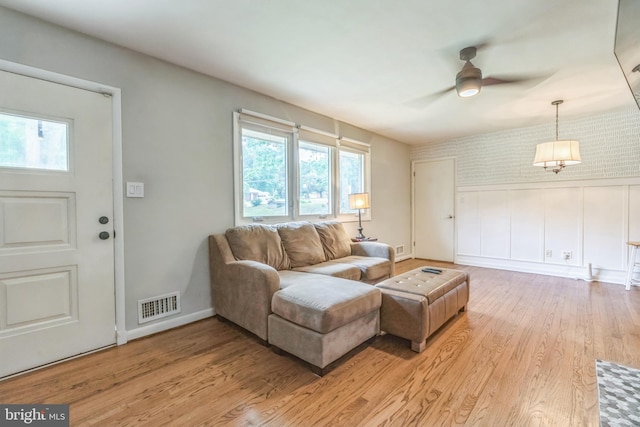 living room featuring healthy amount of natural light, a ceiling fan, and light wood finished floors