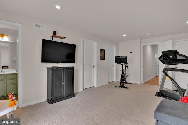exercise room with light colored carpet, baseboards, and recessed lighting