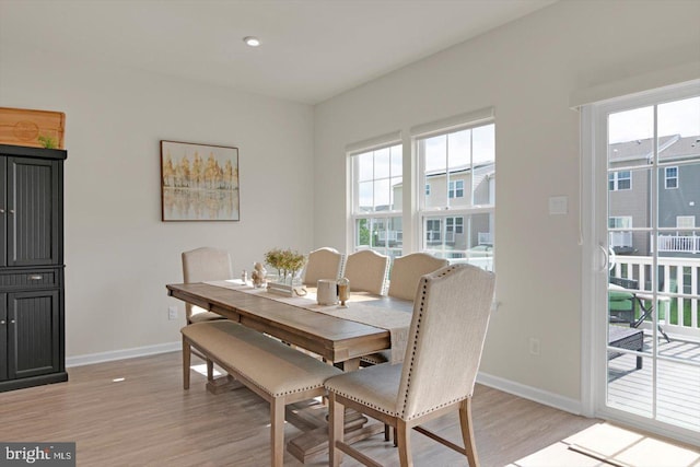 dining space with baseboards and light wood finished floors