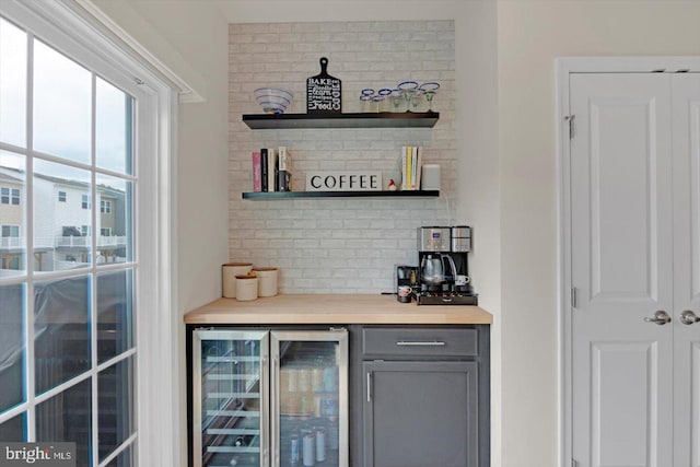 indoor dry bar with wine cooler and backsplash
