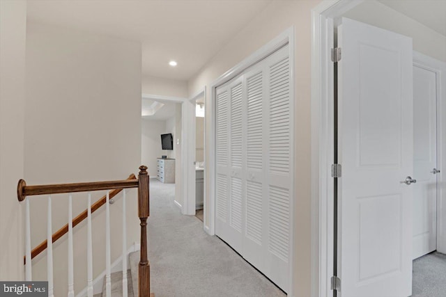 corridor featuring light carpet, an upstairs landing, and recessed lighting
