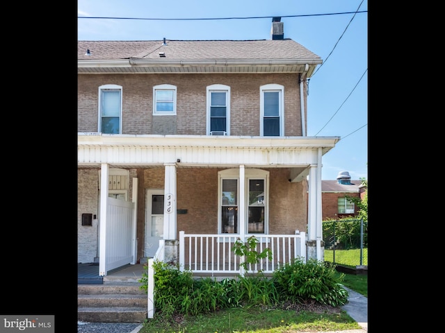 556 W Walnut St, Pottstown, PA 19464 - townhome / multi-family property featuring covered porch, a chimney, and roof with shingles