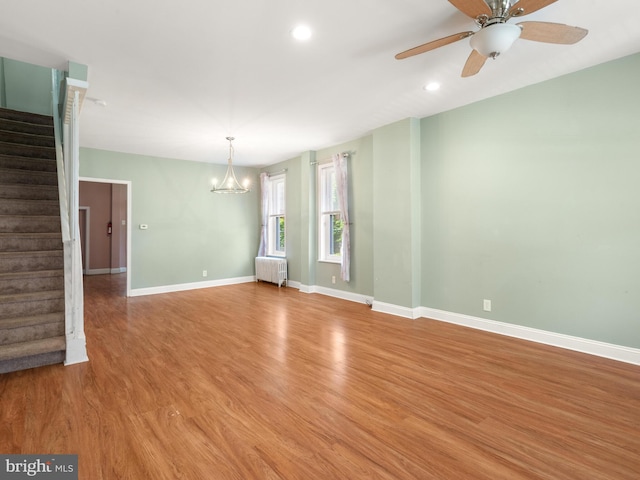 556 W Walnut St, Pottstown, PA 19464 - empty room with radiator heating unit, stairs, baseboards, a chandelier, and light wood finished floors