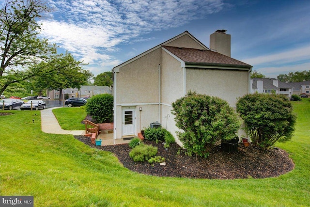 102 Harvest Ln Unit 207, Phoenixville, PA 19460 - view of side of property with a lawn, a chimney, and stucco siding