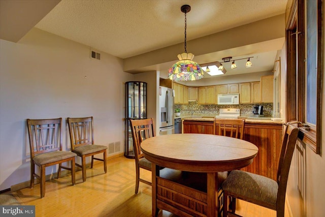 102 Harvest Ln Unit 207, Phoenixville, PA 19460 - dining area with light wood-style floors, baseboards, and a textured ceiling