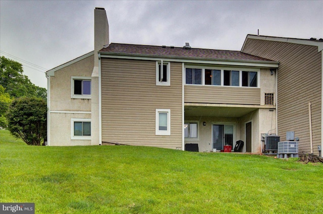 102 Harvest Ln Unit 207, Phoenixville, PA 19460 - back of house with a lawn, cooling unit, a chimney, and stucco siding