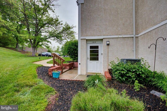 102 Harvest Ln Unit 207, Phoenixville, PA 19460 - view of exterior entry featuring stucco siding and a yard