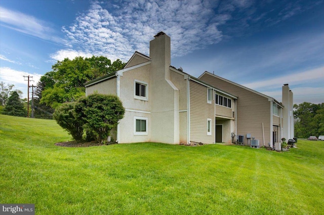 102 Harvest Ln Unit 207, Phoenixville, PA 19460 - back of property with a chimney, central air condition unit, and a yard