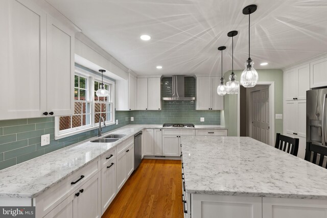 7071 Garden Walk, Columbia, MD 21044 - kitchen with a sink, wall chimney range hood, stainless steel appliances, a kitchen island, and white cabinetry