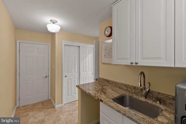 7071 Garden Walk, Columbia, MD 21044 - kitchen featuring a sink, white cabinetry, light stone countertops, and baseboards