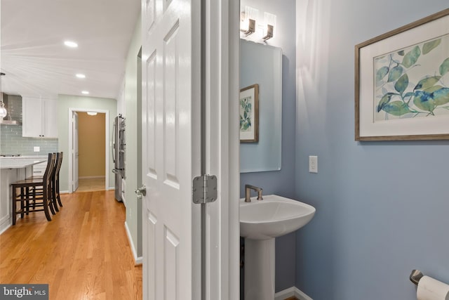 7071 Garden Walk, Columbia, MD 21044 - bathroom with recessed lighting, wood finished floors, decorative backsplash, a sink, and baseboards