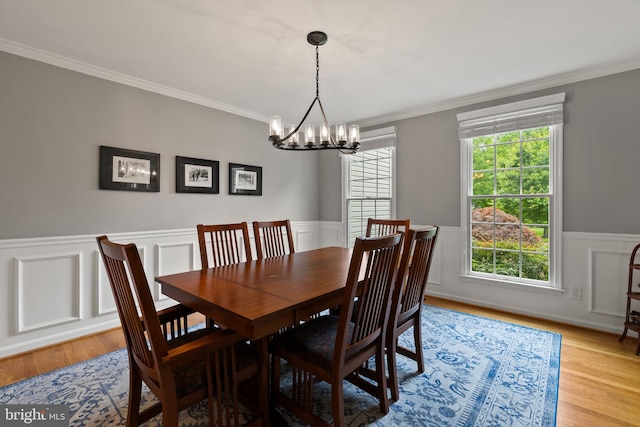 7071 Garden Walk, Columbia, MD 21044 - dining space featuring a chandelier, crown molding, a wainscoted wall, light wood-style flooring, and a decorative wall